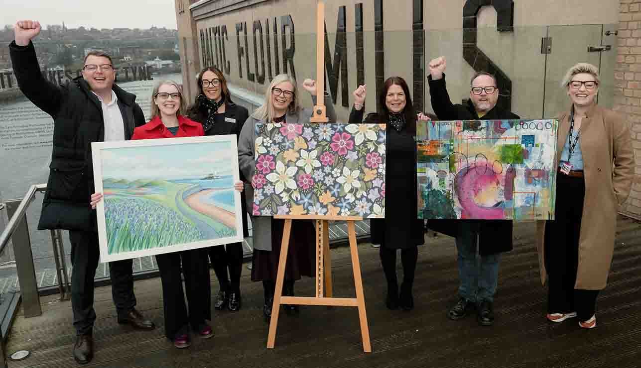 A group of people holding up paintings