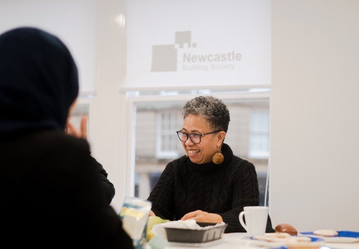 A lady in our South Shields branch community room, smiling at what her friend has said
