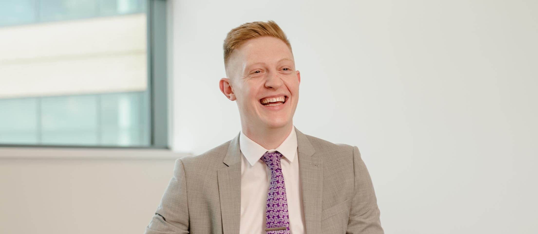 Newcastle Financial Adviser, Elliot Tate, sat in their head office, smiling. 