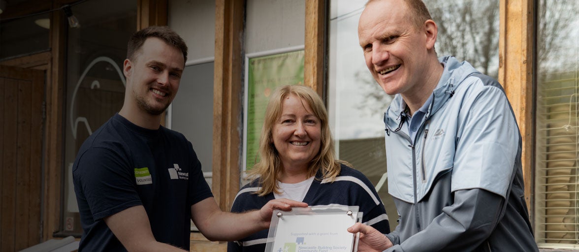 Colleagues holding Community Fund award in Ouseburn