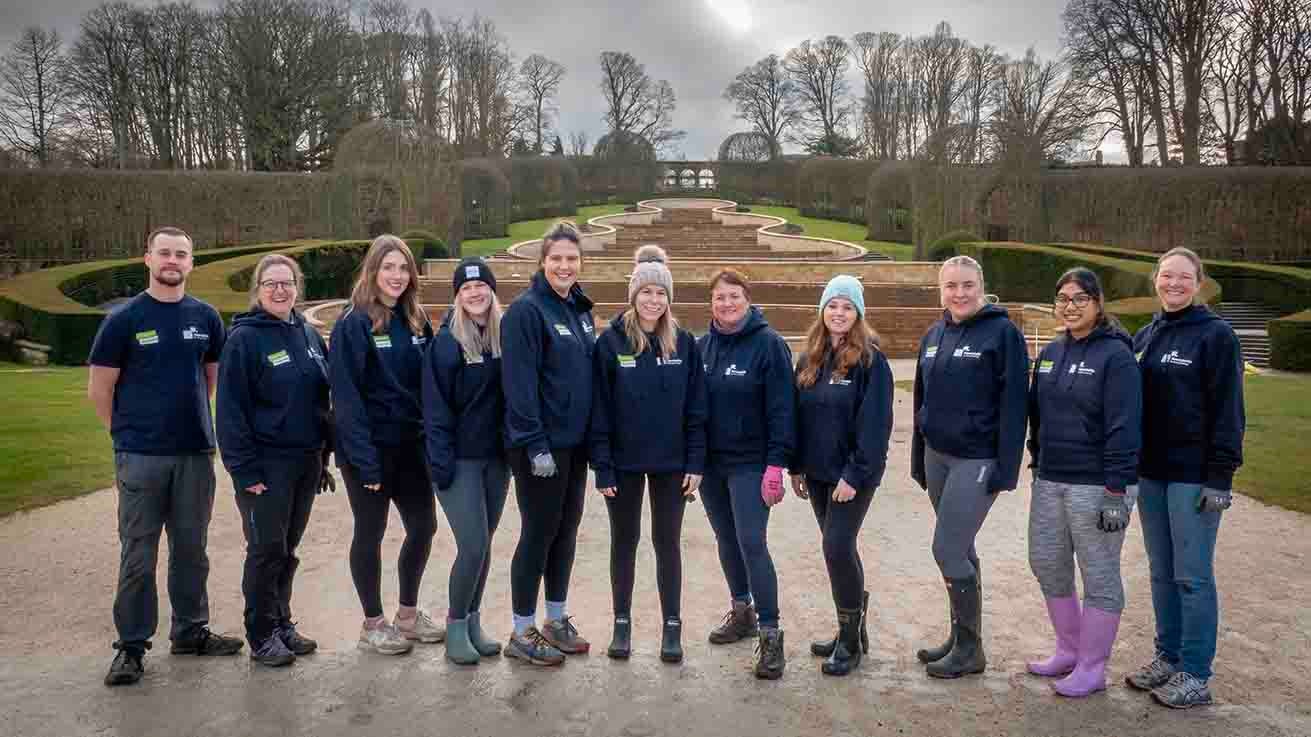 Newcastle Building Society colleagues stood in a group smiling in Alnwick gardens. 
