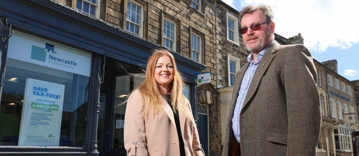 A man and woman stood outside of a building society branch.