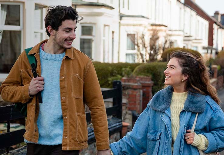 A man and woman holding hands and walking