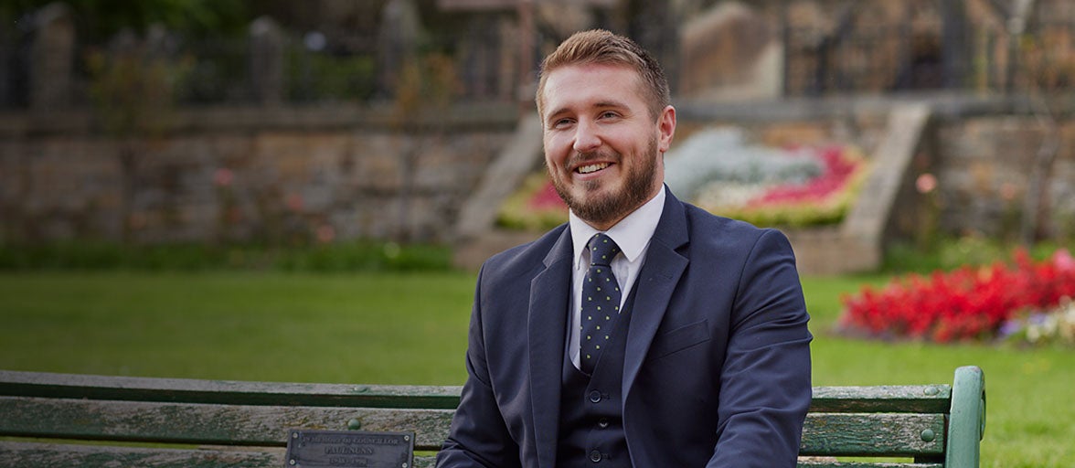 Branch Manager of Newcastle Building Society's Whickham branch, Jonathan Fincken. He in a park smiling. 