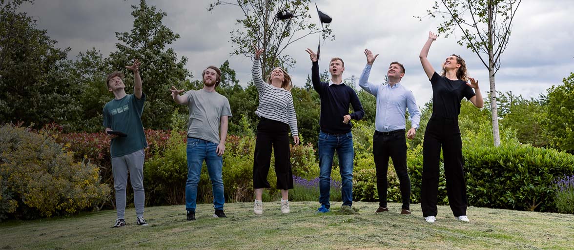 Early Talent graduates throwing caps 