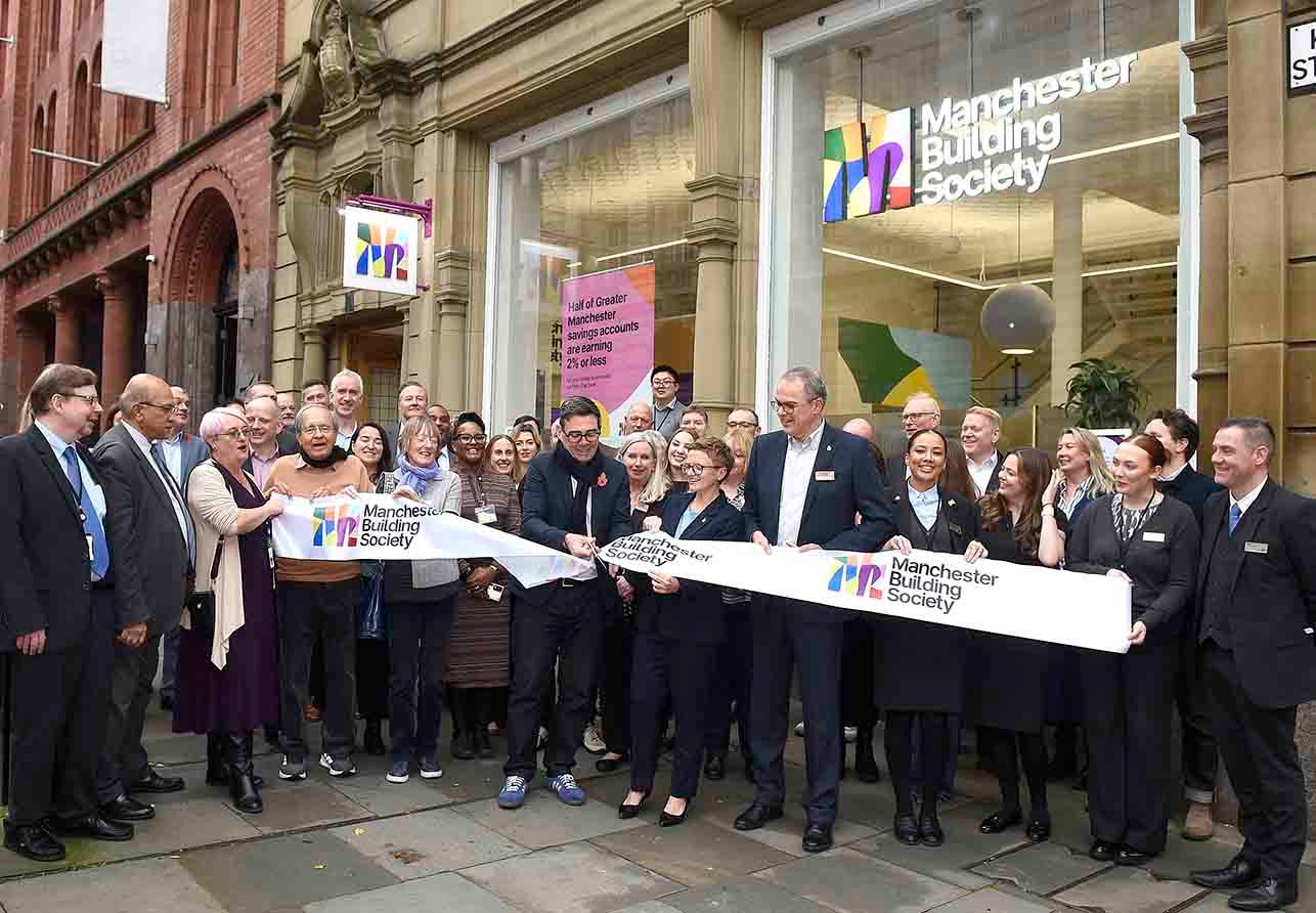 People outside of the Manchester Building Society branch, cutting the opening ceremonial ribbon. 