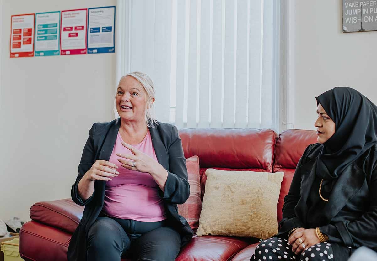 Two women sat on a sofa talking at the Park Foundation charity. 