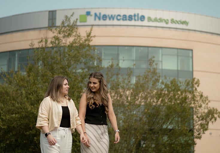 Two ladies walking outside of the Newcastle Building Society head office. 
