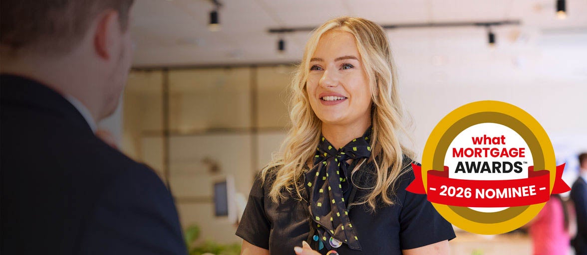 Photo of a branch colleague smiling in the Monument branch. With the What Mortgage Awards 2026 nominee logo. 