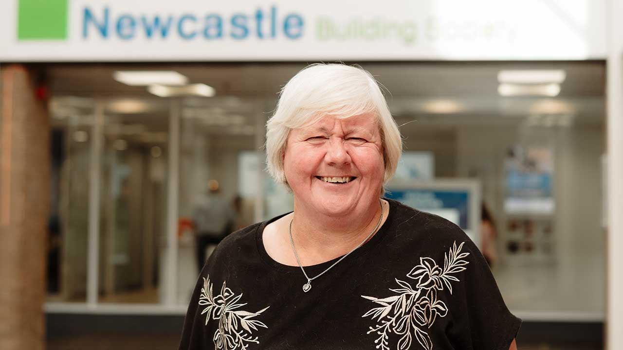 A Newcastle Building Society member, Brenda, stood outside the Cramlington branch smiling. 