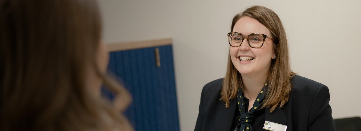 A customer service assistance in Newcastle Building Society's Middlesbrough branch, smiling at a customer.