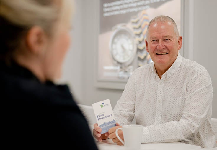 A customer sat in the West Denton branch with a customer assistant, smiling. 