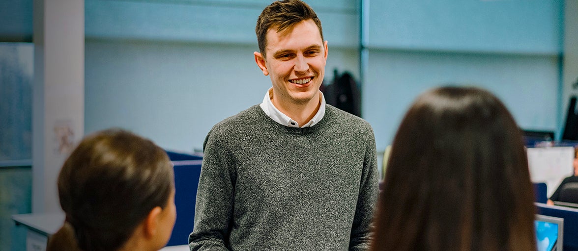 A man smiles at two women.