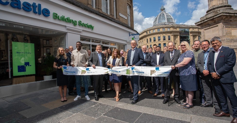 Newcastle Building Society colleagues, customers, and community partners getting ready for a ribbon cutting.