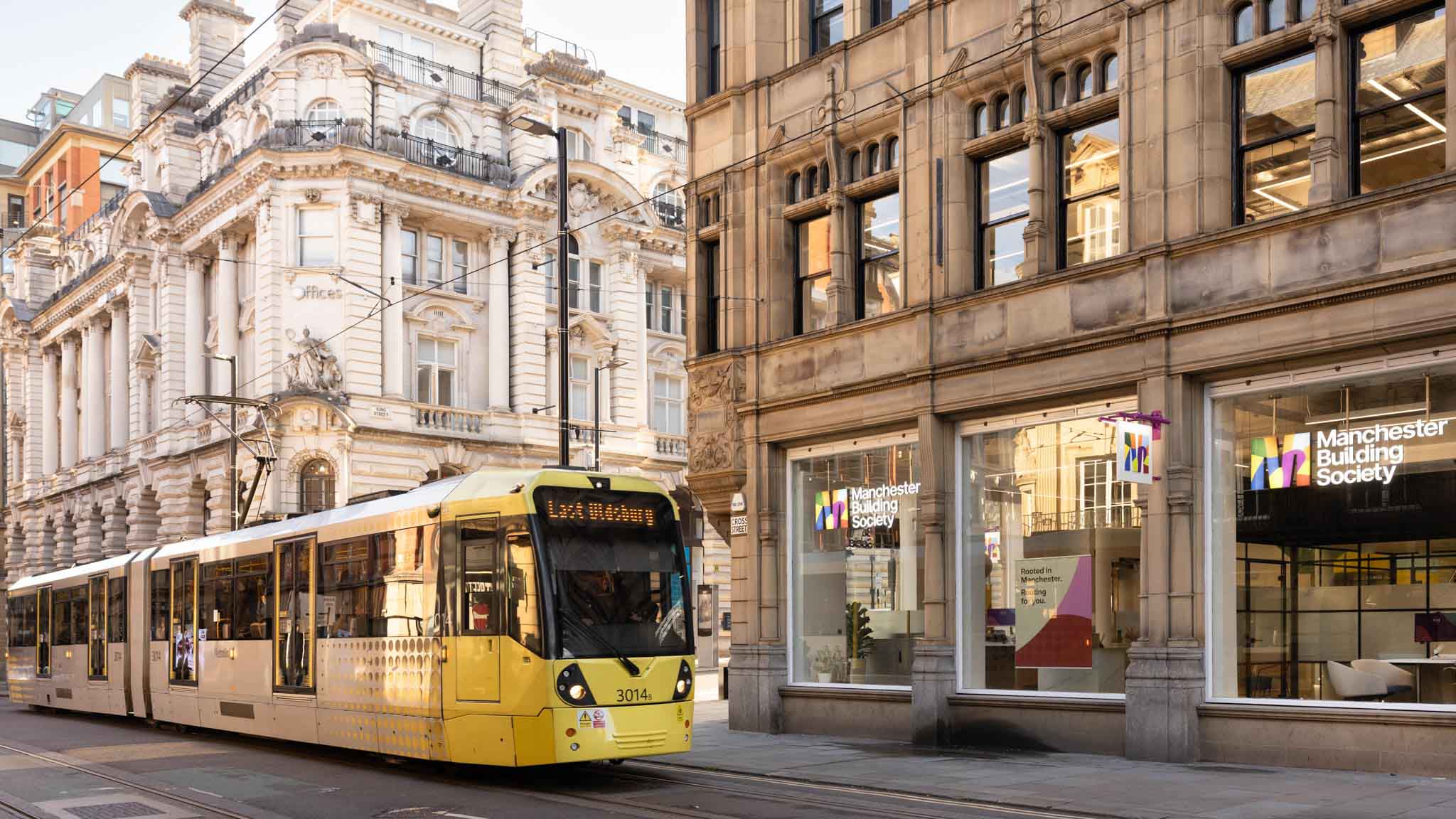 A yellow tram outside the King Street Manchester Building Society branch.  
