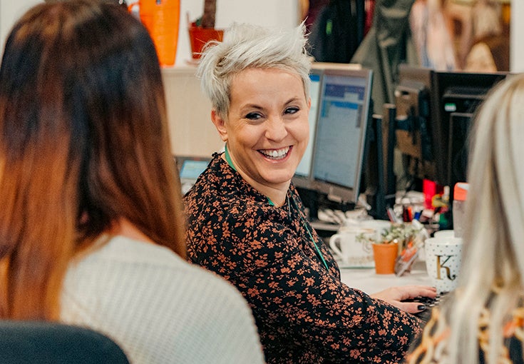 A colleague laughing with two people/