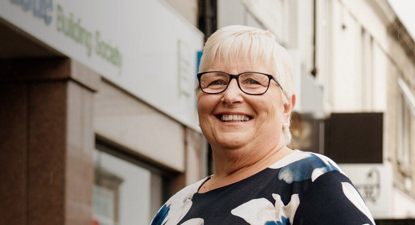 Customer smiling in front of the Gosforth branch. 