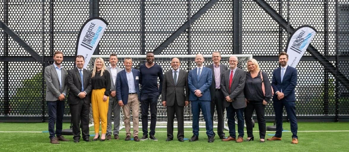 A group of Newcastle Foundation members and supports standing in front of a goal at the new NUCASTLE building.
