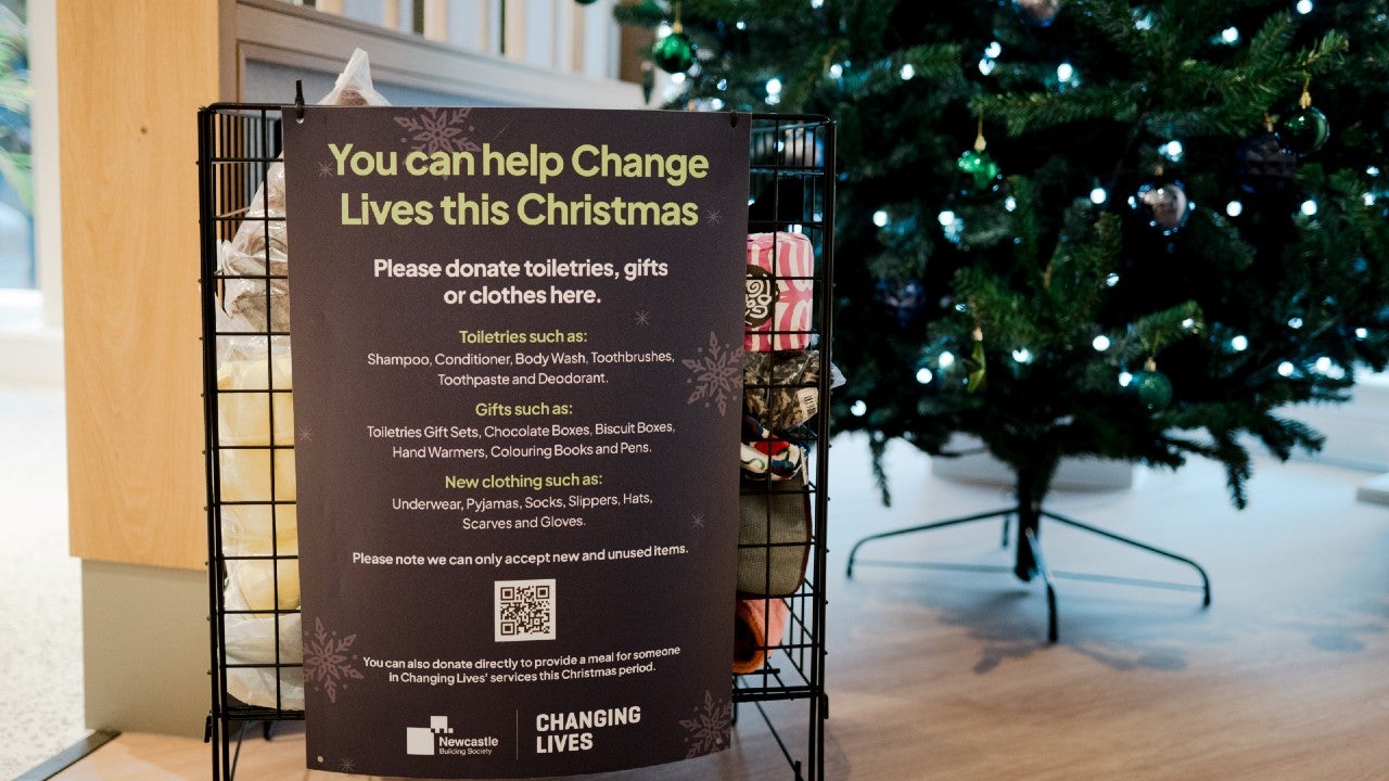 A charity donation bin beside a Christmas tree