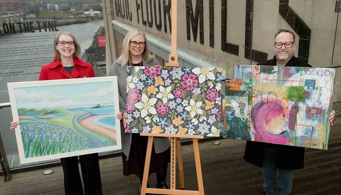 A group of three artists holding their passbook design paintings