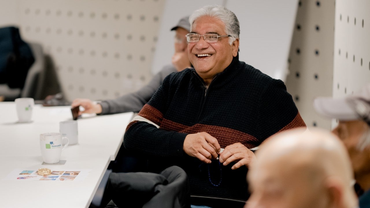 A man sat at a table smiling.