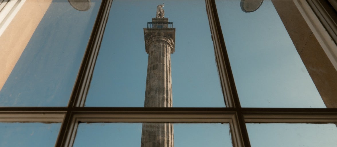 A tall stone tower seen through a window.