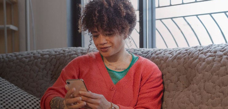 A woman smiling at her phone