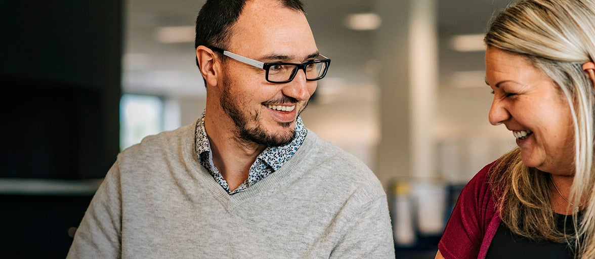 Two colleagues sat together laughing