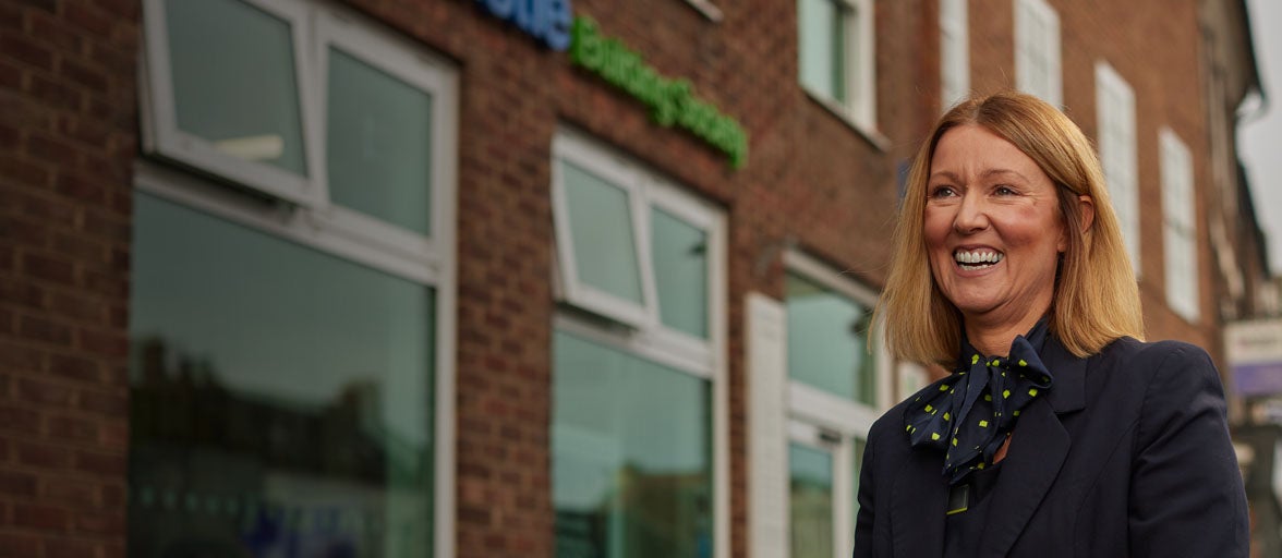 Yarm's Branch Manager, Bev. Stood in front of the branch smiling. 