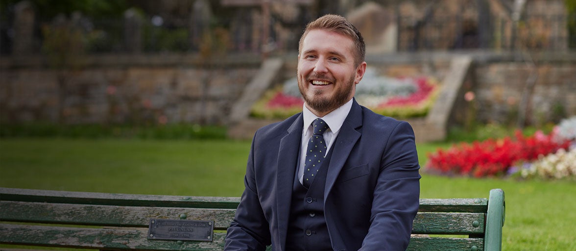 Whickham's Branch Manager, Jonathan Fincken, sat on a park bench in Whickham. 
