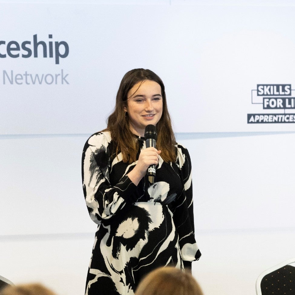 A Newcastle Building Society colleague stood on stage holding a microphone. 