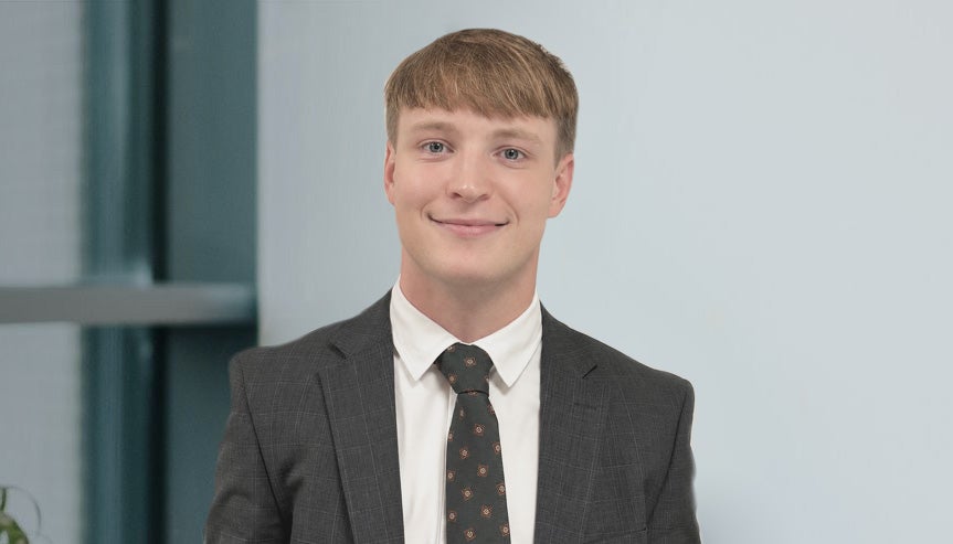 Newcastle Financial Adviser, Alex Ford, sitting in a room smiling.