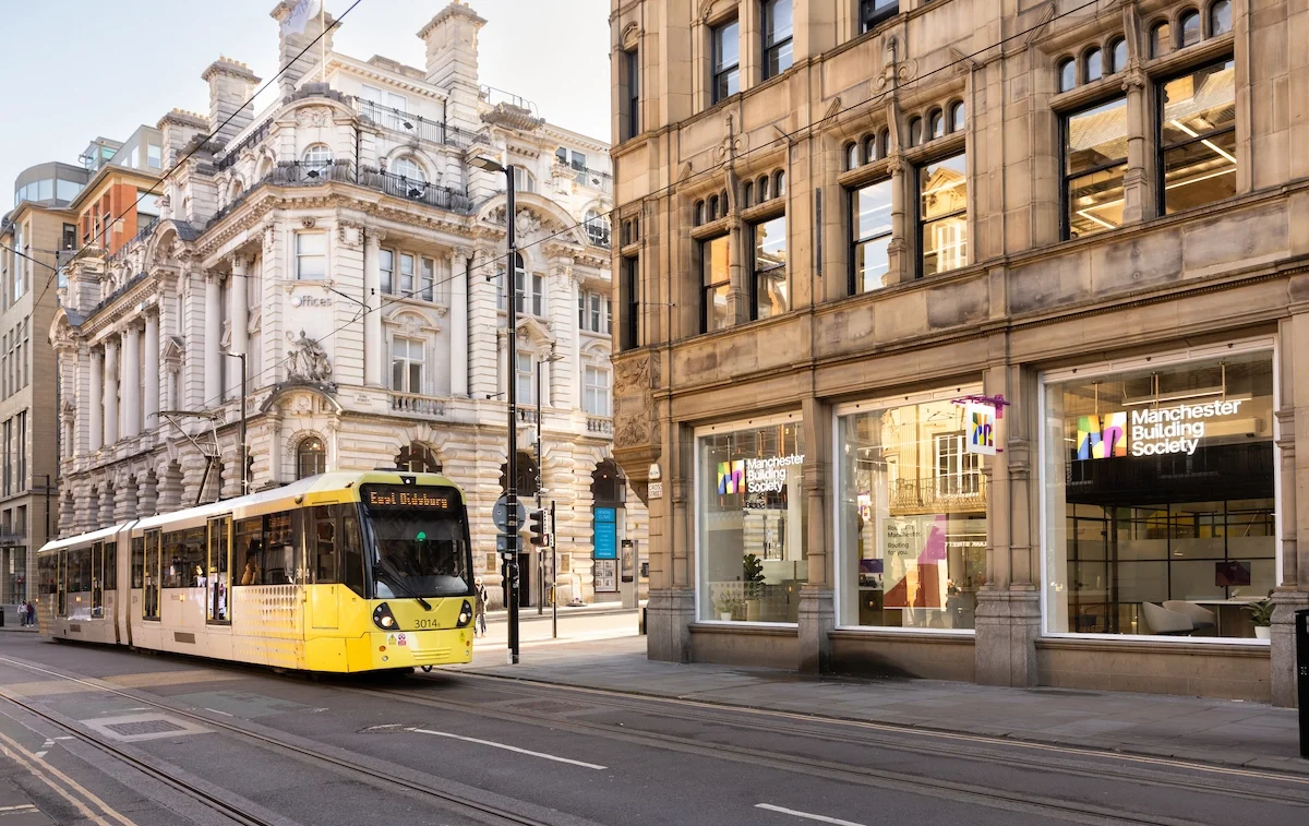 A yellow tram on a Cross Street, Manchester, outside the King Street branch of Manchester Building Society