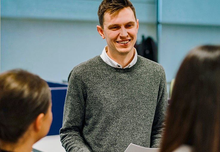 A man smiles at his colleagues