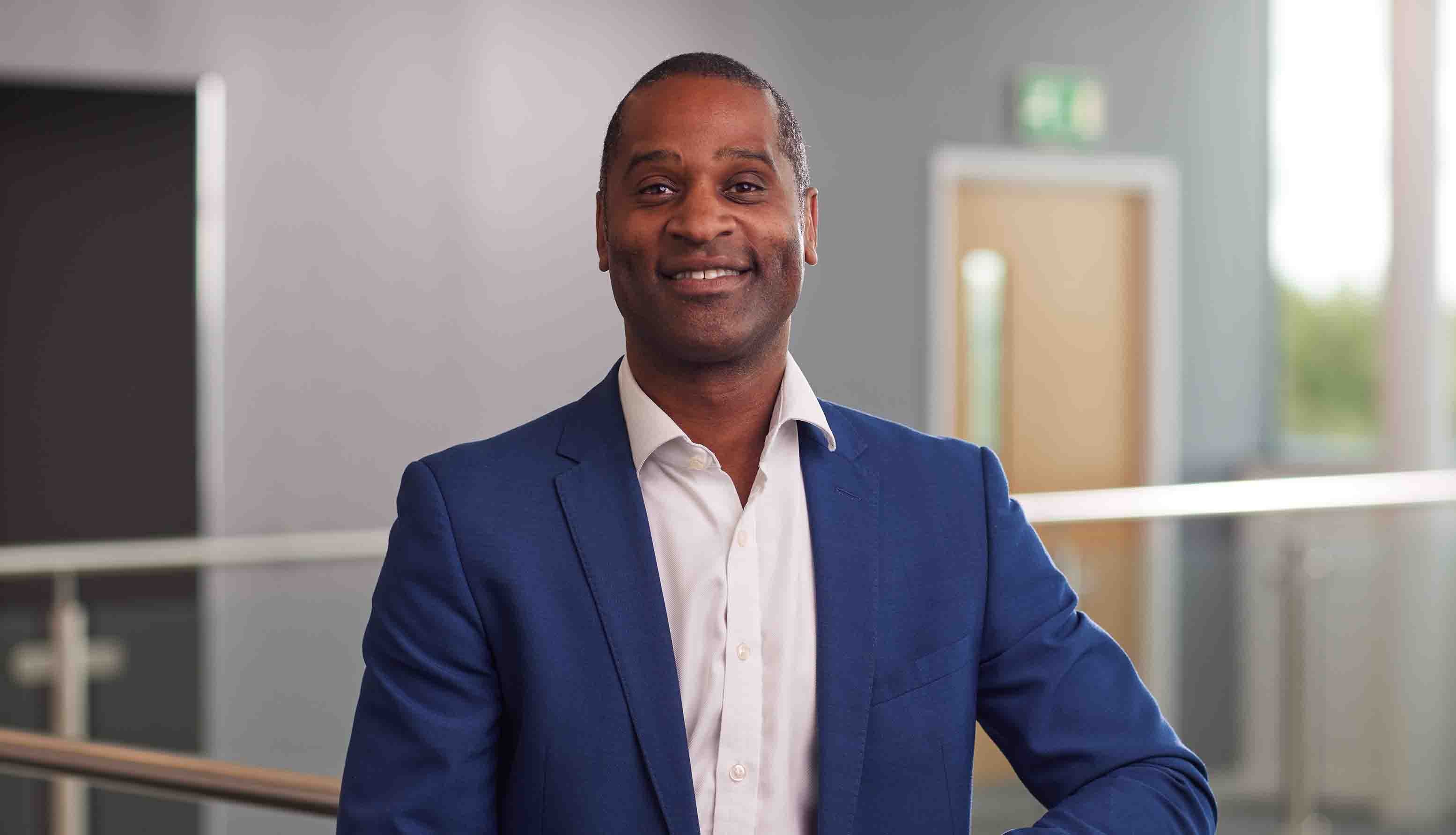 Newcastle Building Society's non-executive director, Rory Campbell, stood on a balcony inside their Cobalt head office, smiling at the camera.