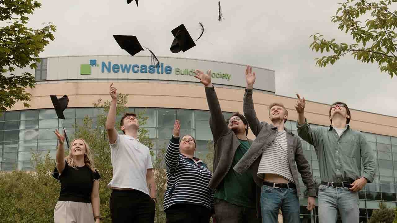 A group of people throwing graduation caps in the air
