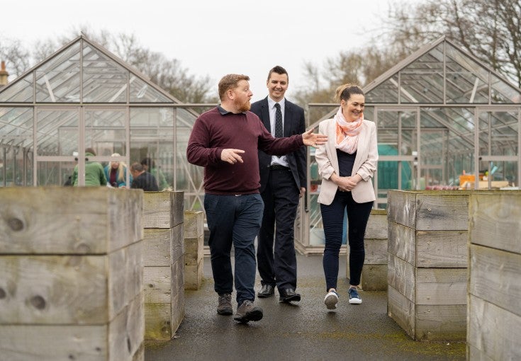 The Operations Manager at Full Circle Food Project showing two Newcastle Building Society colleagues around the centre's community garden.