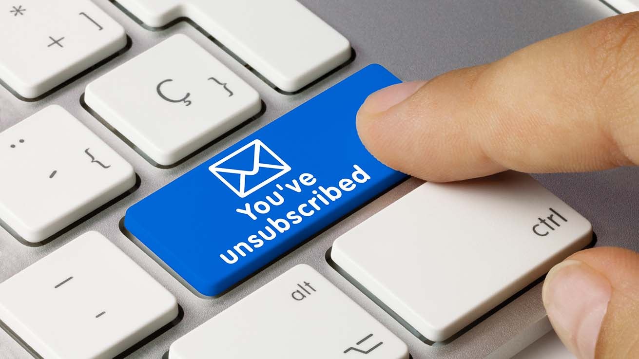 A finger pressing a blue button on a keyboard