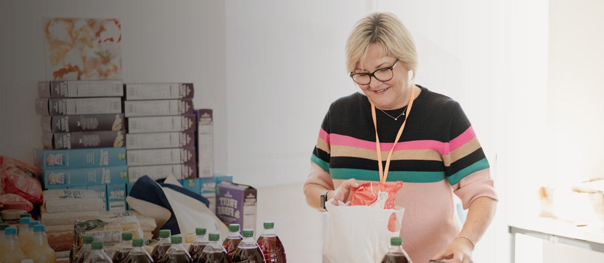 Woman packing a bag with food donations. 