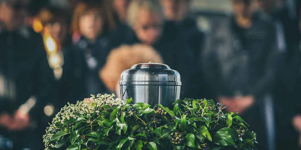 An urn sitting within a memorial wreath at a cremation