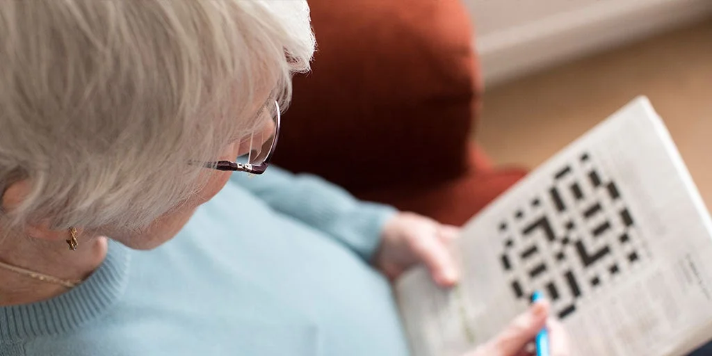 Woman doing a crossword in a newspaper