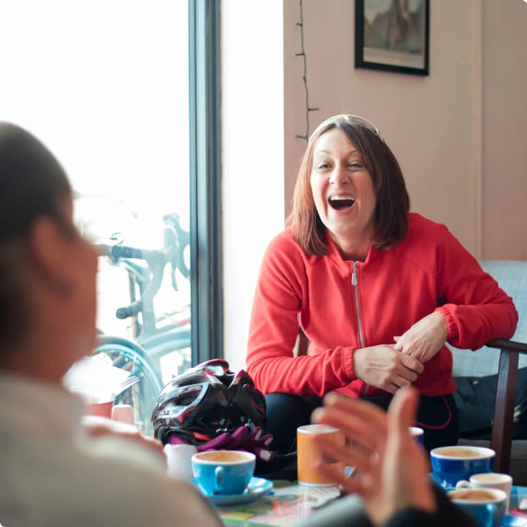 2 friends smiling and laughing in a café