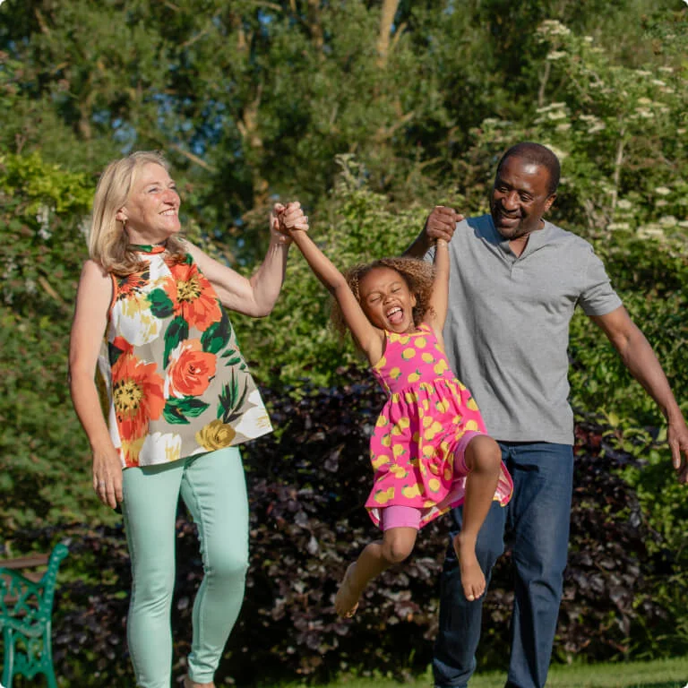 Couple playing with a child while laughing.