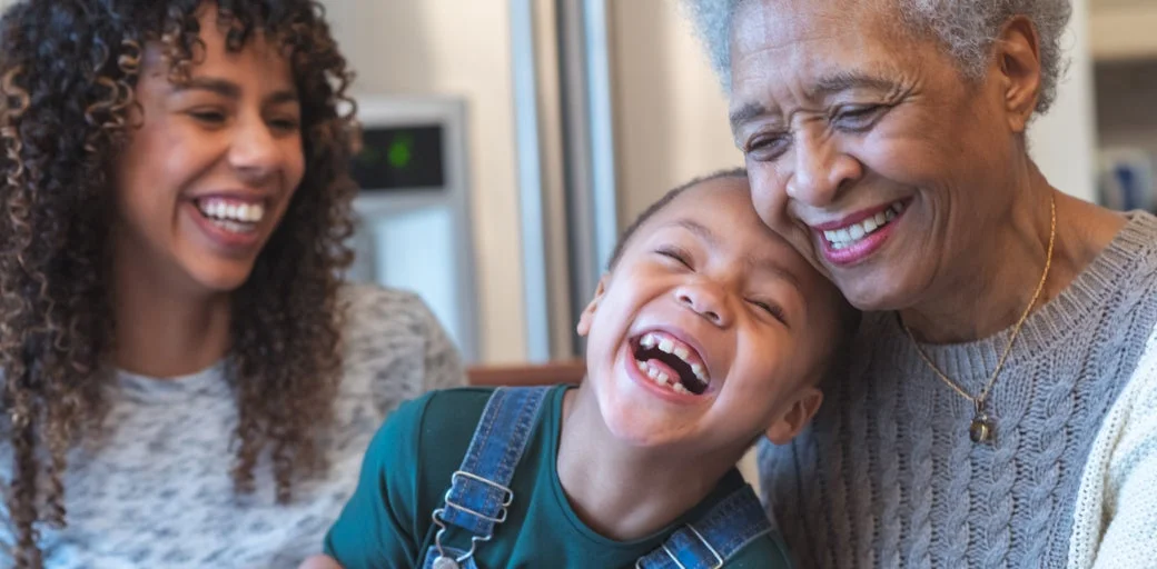 Grandmother laughing with her daughter and grandson