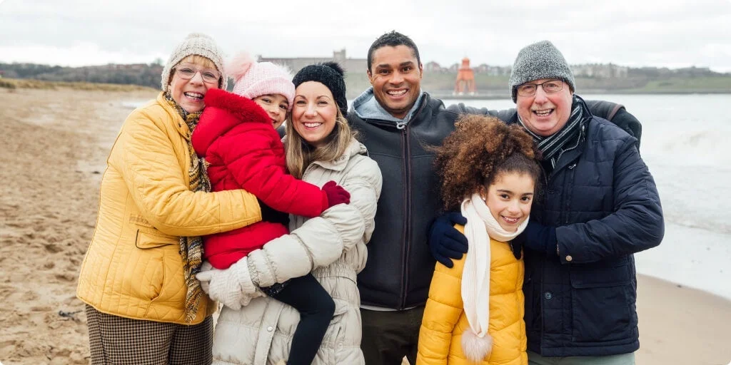 Family posing for a photo on the beach.