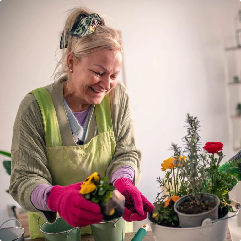 Woman planting some flowers into plant pots.