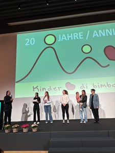 Vorstellung der Sonderedition „Mountain-Rigel mit Herz“ bei der Vollversammlung von Verein Kinderherz im Hotel Sheraton in Bozen am Samstag, 11.04.2026 v. l. n. r. Ulrich Seitz, Präsident – Verein Kinderherz, Lena Pichler, Obfrau der Schülergenossenschaft, Francesca Maria Gentile, Mitglied des Verwaltungsrates, Marion Unterholzner, Koordinatorin der Müsli-Produktion, Melanie Resch mit Tochter, eine Promotorin des Mountain Müslis / Verein Kinderherz – Mitglied und Christine Gutgsell, Koordinatorin der Schülergenossenschaft Foto: FS Tisens
