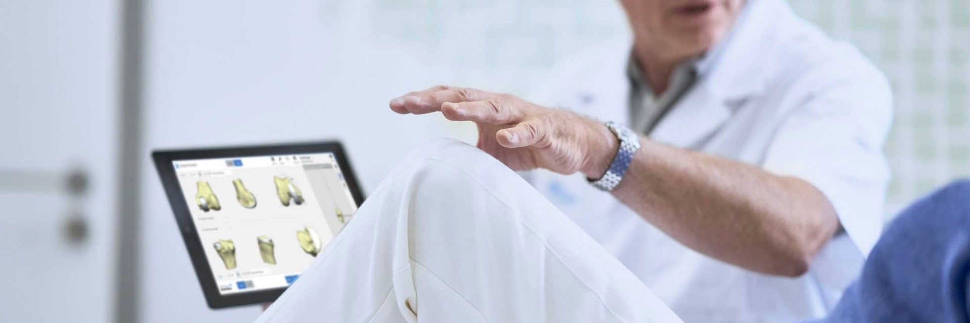 Surgeon speaking to a patient while holding a tablet with 3D planning software