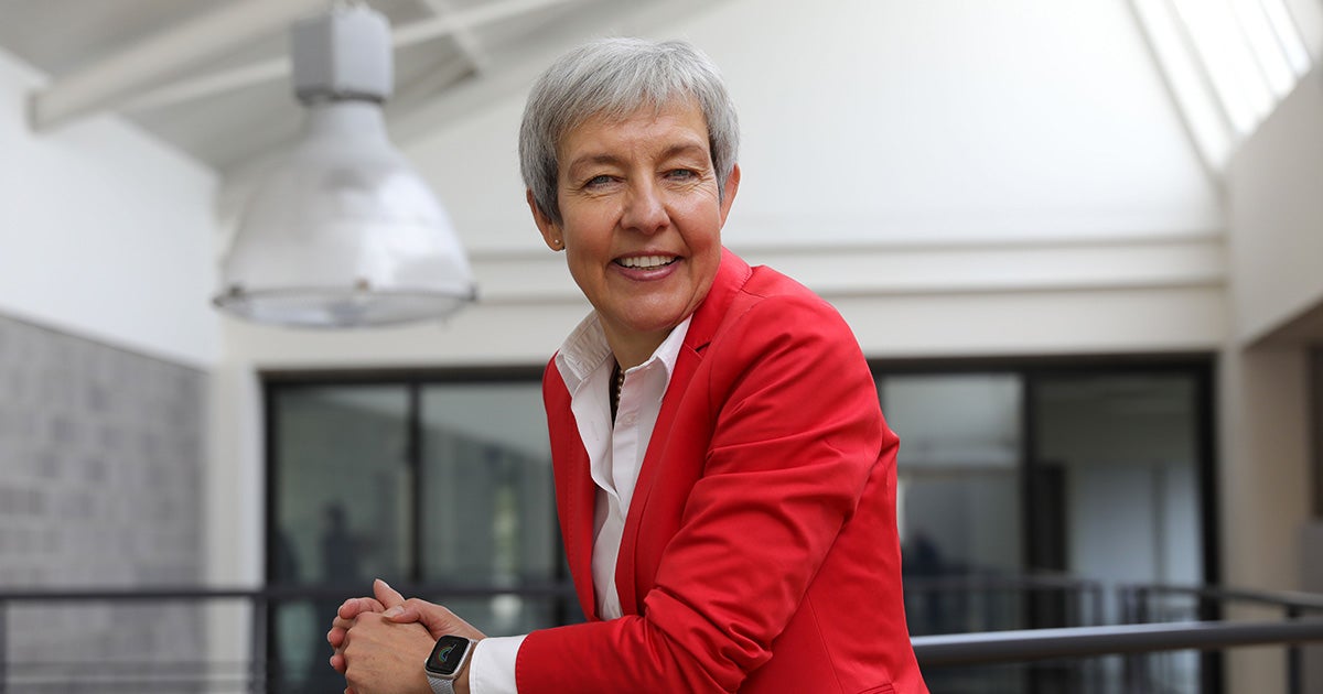 Brigite de Vet-Veithen smiling while leaning on a railing in the Materialise office