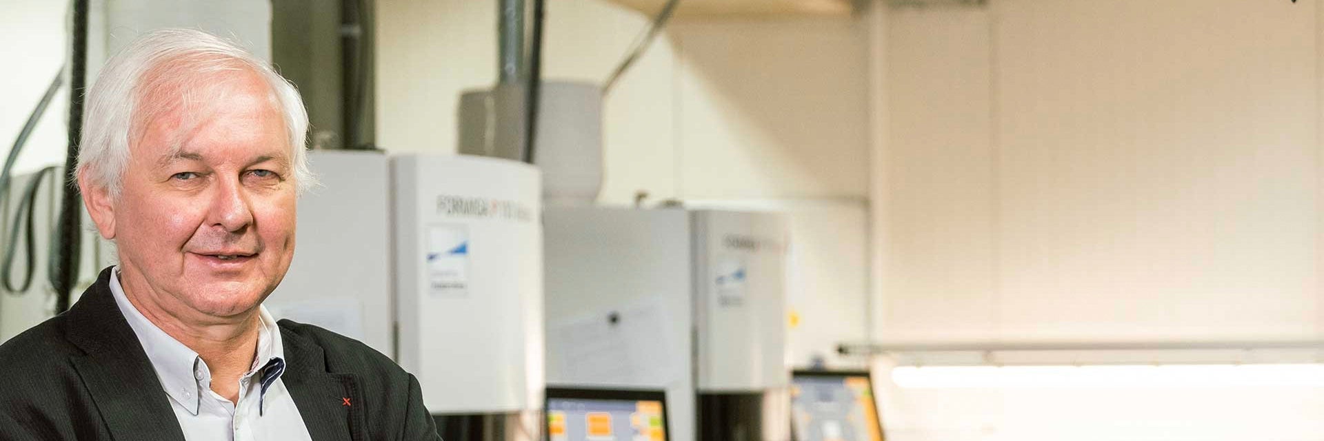 Fried Vancrean, CEO of Materialise, standing in front of several 3D printers.